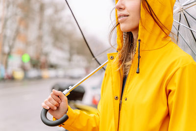 Woman holding umbrella in city