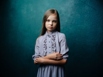 Portrait of girl standing against wall