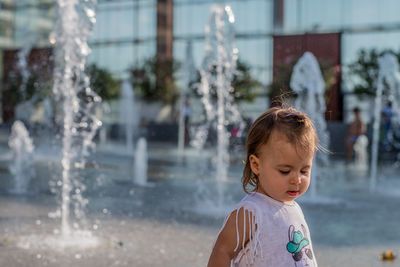 Cute girl standing at fountain