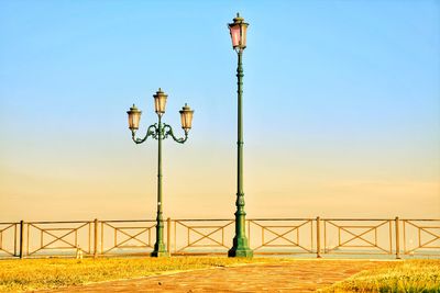 Street light and bridge against clear blue sky