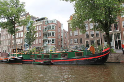 Boats in canal by buildings in city