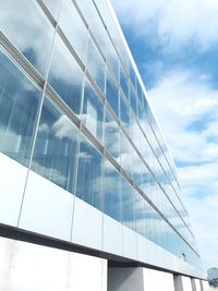 Low angle view of glass building against sky