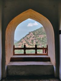 Nature theories- view of the hills from inside of an arched window of a fort