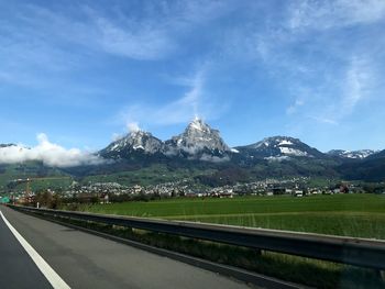 Road leading towards mountains against sky