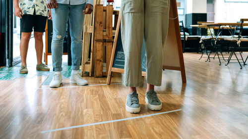 Low section of people standing on wooden floor