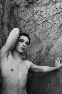 Young male with  androgynous look shot outdoor in black and white with rocks in background.