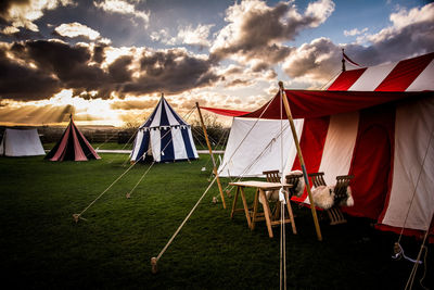 View of colorful tents beneath cloudy sky