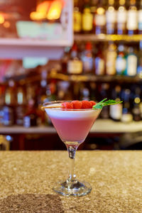 Close-up of drink in martini glass on table at bar