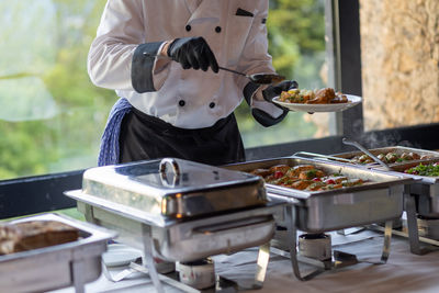 Midsection of man preparing food in kitchen