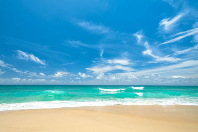 Scenic view of beach against blue sky