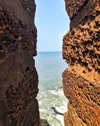 Rock formation on beach against sky