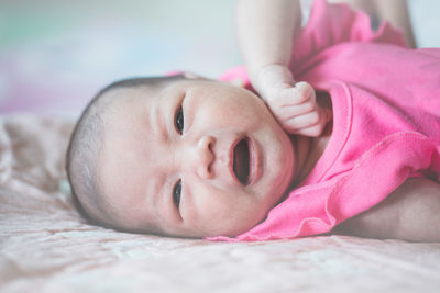 Close-up of baby boy lying on bed