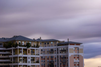 Low angle view of buildings against dramatic sky