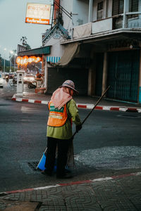 Rear view of man working on street