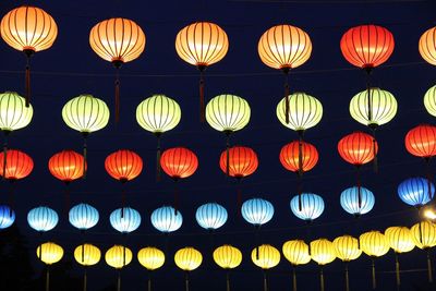 Low angle view of illuminated lanterns hanging at night