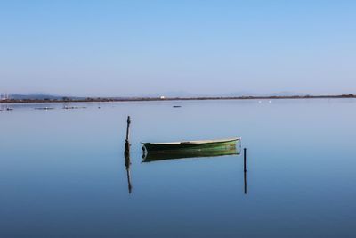 Lifeguard hut in lake against clear blue sky