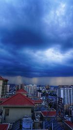 Buildings in city against cloudy sky