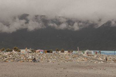 Panoramic view of people on beach against sky