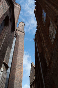 Low angle view of buildings against cloudy sky