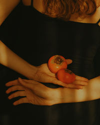 Midsection of woman holding fruit