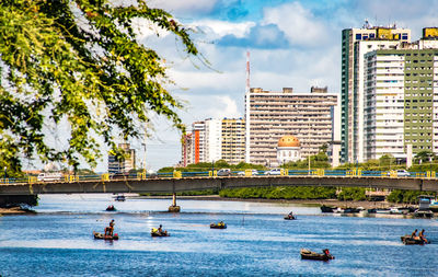 Boats in swimming pool against buildings in city