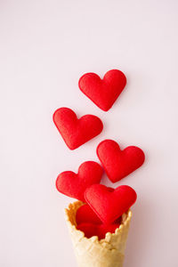 Close-up of heart shape cake against white background