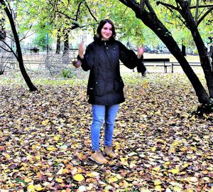 Full length of smiling young woman during autumn