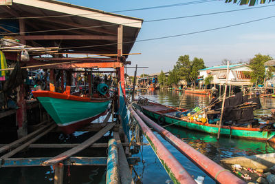 Boats moored on shore against sky