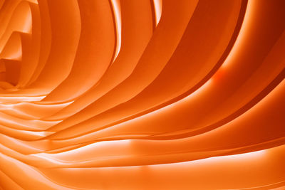 Orange wavy design background with light
