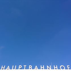 Low angle view of trees against clear blue sky