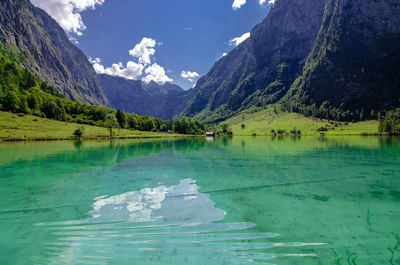 Scenic view of lake by mountains against sky