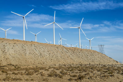 Wind turbines on land against sky