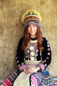 Portrait of a smiling young woman against wall