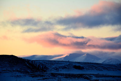 Scenic view of snow covered mountains against sky during sunset