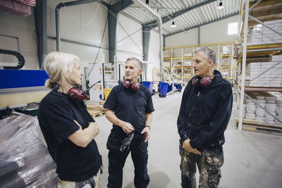 Male and female workers discussing in meeting at lumber industry