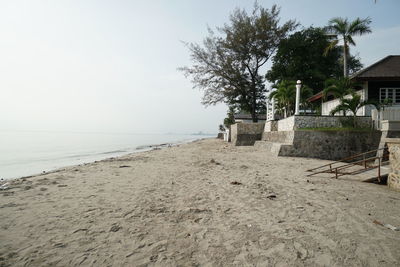 Scenic view of beach by sea against clear sky