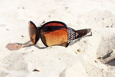 Close-up of sunglasses on beach