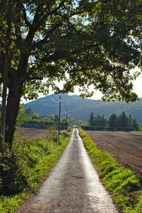 Road amidst field against sky