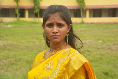 Portrait of girl standing on grass outdoors