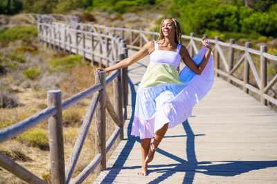 Rear view of woman standing on railing