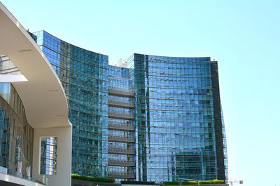 Low angle view of modern building against clear blue sky