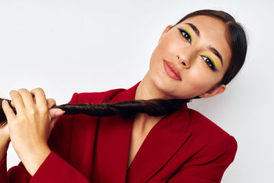 Portrait of young woman against white background