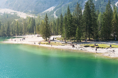Braies, italy september 10, 2021 people on the braies lake admires the mountains during a sunny day