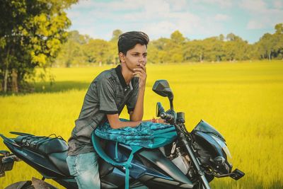 Young man sitting on field