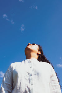 Low angle view of man looking at blue sky