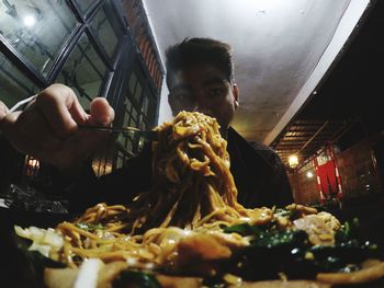 Portrait of man having noodles at restaurant