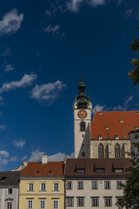 Low angle view of buildings in town against blue sky