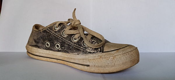 Close-up of shoes on table against white background