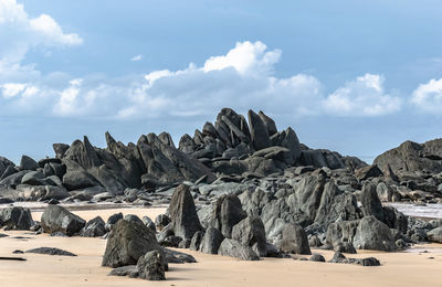 Panoramic view of rocks on beach against sky