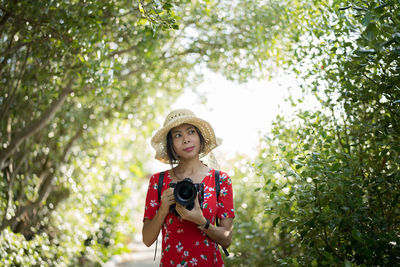 Portrait of woman standing against plants